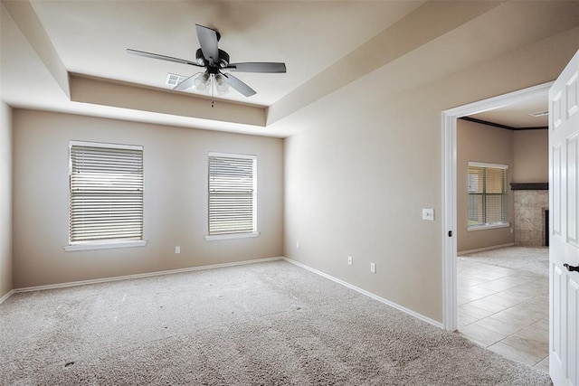 4536 Oasis Ct, Yukon, OK 73099 - empty room featuring light carpet, baseboards, ceiling fan, and a raised ceiling