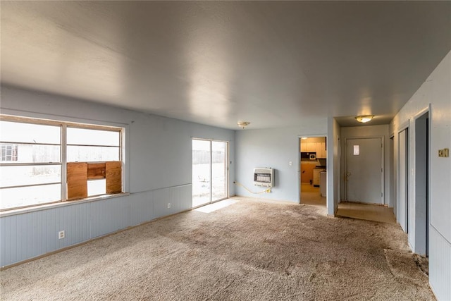 unfurnished living room with carpet floors and heating unit