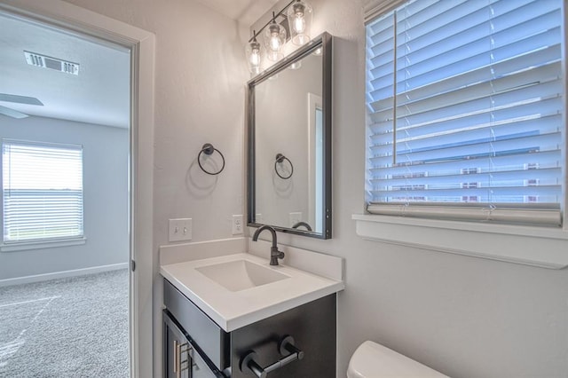 bathroom featuring vanity, toilet, and ceiling fan