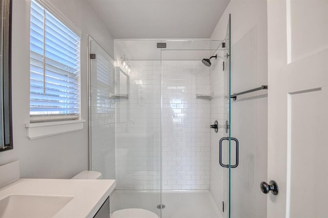 bathroom with vanity, toilet, and a shower with door