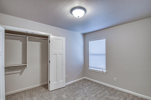 unfurnished bedroom featuring light carpet and a closet