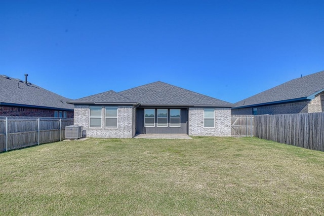 rear view of property featuring a yard and cooling unit