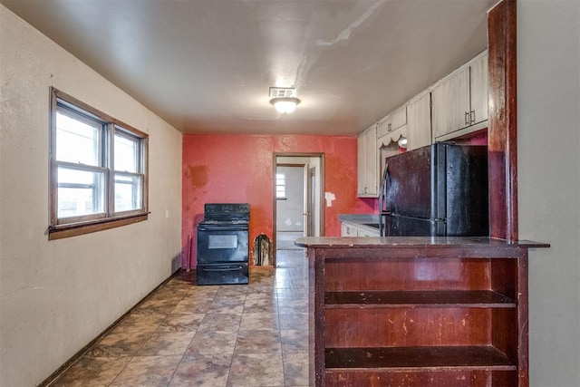 kitchen with a wood stove and black appliances