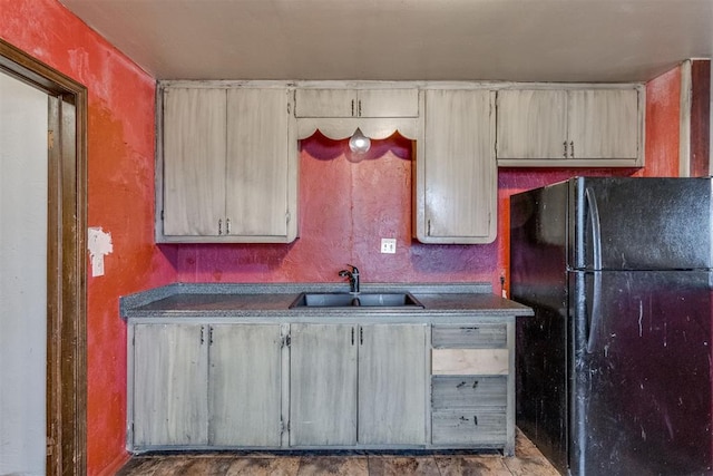 kitchen featuring sink, light brown cabinets, and black fridge