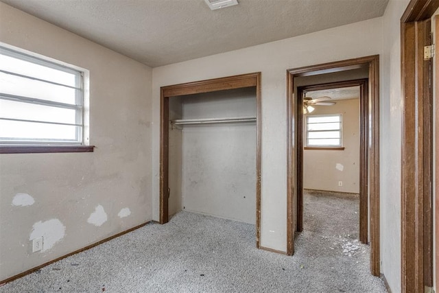 unfurnished bedroom featuring light carpet, a textured ceiling, and a closet