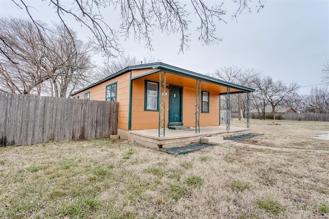 bungalow featuring a front yard and fence