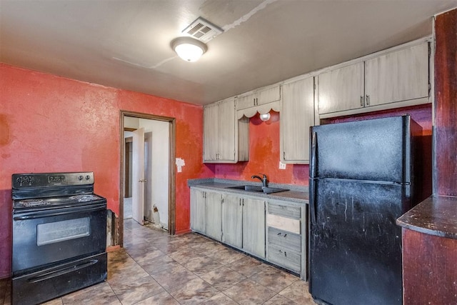 kitchen featuring a sink, visible vents, black appliances, and a textured wall