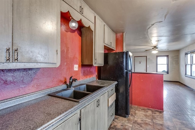 kitchen with freestanding refrigerator, a sink, and a ceiling fan