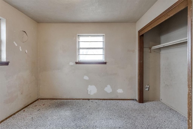 unfurnished bedroom featuring carpet floors, baseboards, a closet, and a textured ceiling