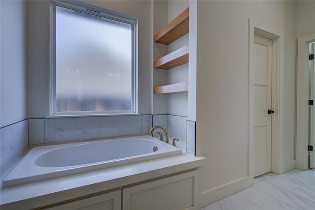 bathroom featuring a tub to relax in and a healthy amount of sunlight