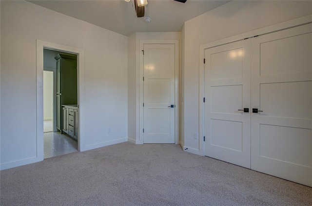 unfurnished bedroom with ceiling fan, light carpet, and a closet