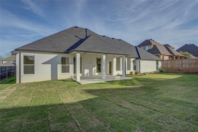 rear view of property featuring a yard and a patio area