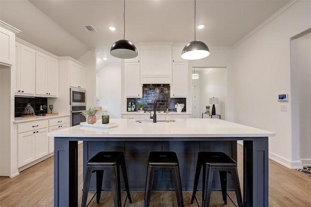 kitchen featuring white cabinetry, a kitchen island with sink, and appliances with stainless steel finishes