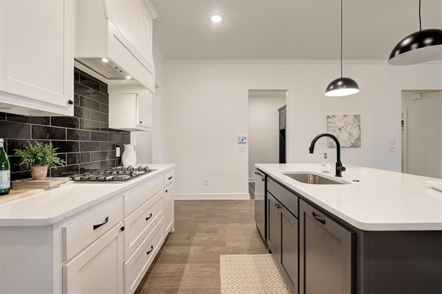 kitchen featuring sink, stainless steel appliances, hanging light fixtures, and white cabinets