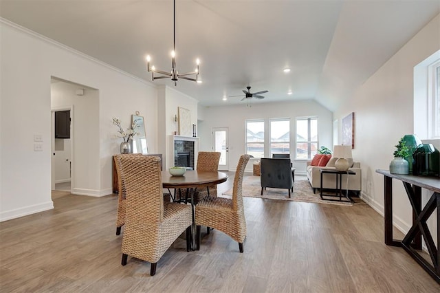 dining area with ceiling fan with notable chandelier, ornamental molding, and light hardwood / wood-style floors