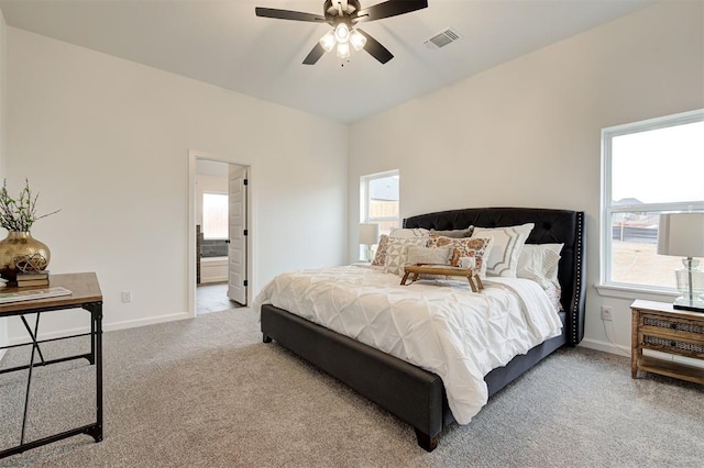 bedroom featuring ceiling fan, light colored carpet, and ensuite bathroom