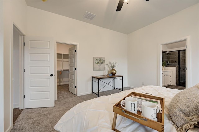 bedroom with ceiling fan, connected bathroom, a spacious closet, light colored carpet, and a closet