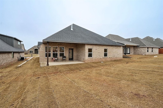 rear view of property with central AC, a patio area, and a lawn