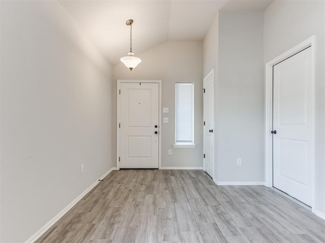 foyer entrance featuring light wood-type flooring and vaulted ceiling