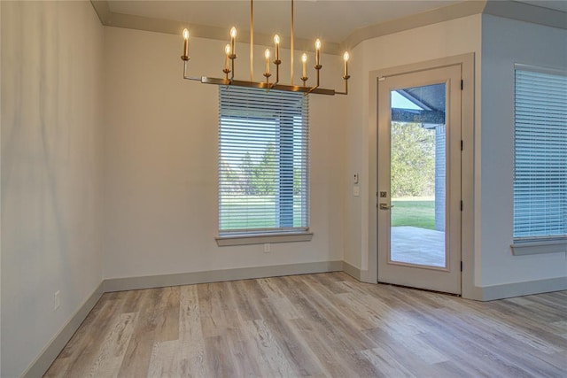 doorway with light hardwood / wood-style flooring and a notable chandelier