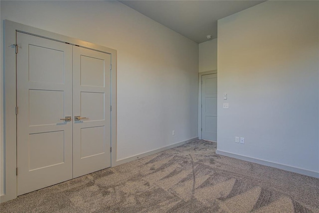 unfurnished bedroom featuring a closet and light colored carpet