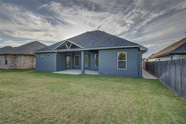 rear view of property featuring a patio area and a yard