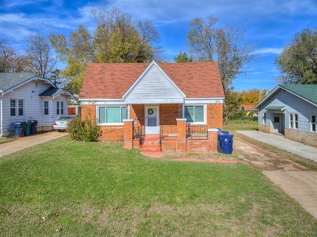 bungalow-style home with a front yard and covered porch