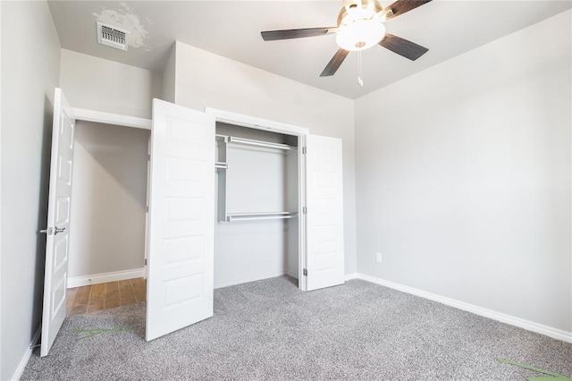 unfurnished bedroom with a closet, baseboards, carpet flooring, visible vents, and ceiling fan