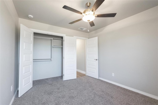 unfurnished bedroom with a closet, baseboards, carpet flooring, visible vents, and ceiling fan