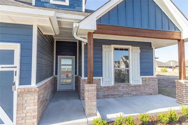 entrance to property featuring a porch, board and batten siding, and stone siding