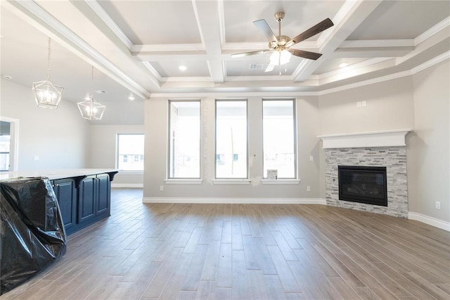 unfurnished living room featuring wood finished floors, beamed ceiling, and a ceiling fan