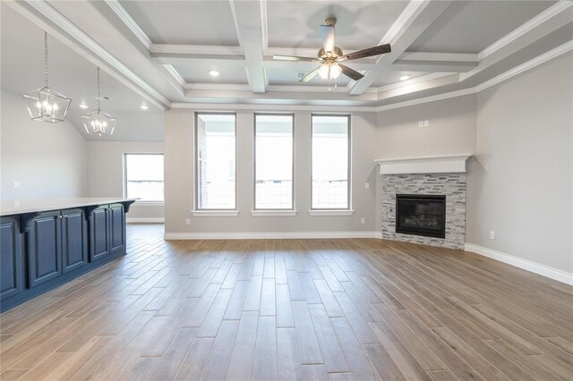 9301 NW 116th St, Yukon, OK 73099 - unfurnished living room with a ceiling fan, crown molding, light wood finished floors, a glass covered fireplace, and a chandelier