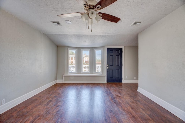 interior space with ceiling fan, dark hardwood / wood-style flooring, and a textured ceiling