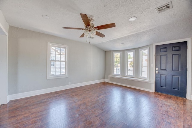 foyer entrance with dark hardwood / wood-style flooring, a textured ceiling, and a wealth of natural light