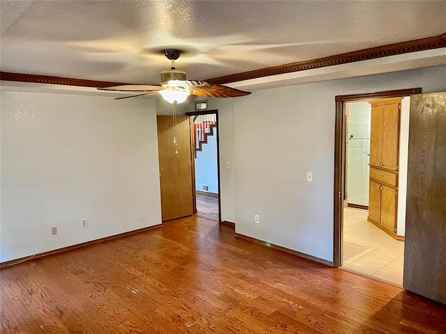 spare room featuring ceiling fan, a textured ceiling, and light hardwood / wood-style floors