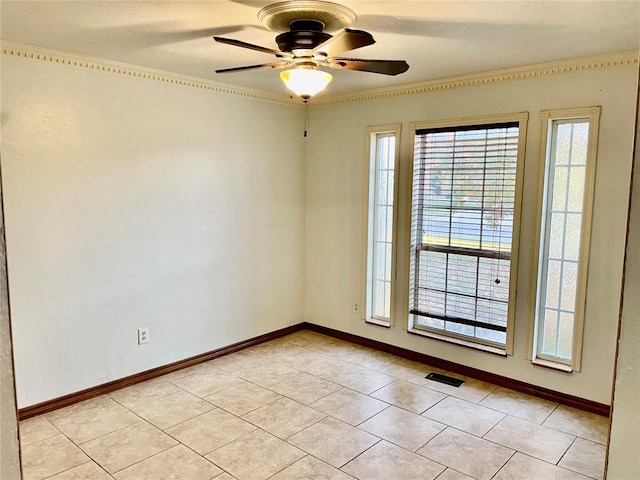 empty room featuring ceiling fan, light tile patterned floors, and ornamental molding