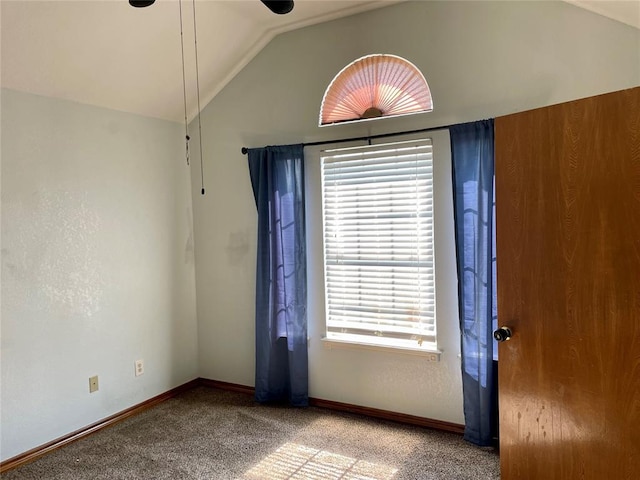 carpeted spare room featuring vaulted ceiling