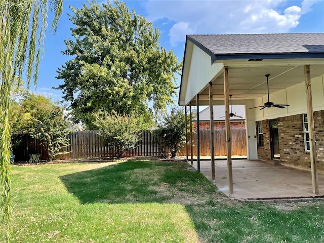 view of yard with ceiling fan and a patio