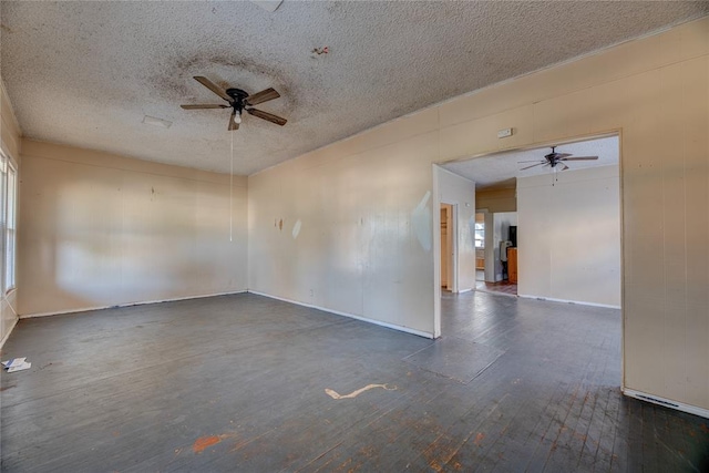 empty room featuring a textured ceiling, ceiling fan, and dark hardwood / wood-style floors