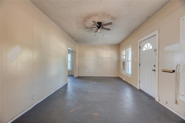 foyer featuring ceiling fan, dark hardwood / wood-style floors, and a textured ceiling