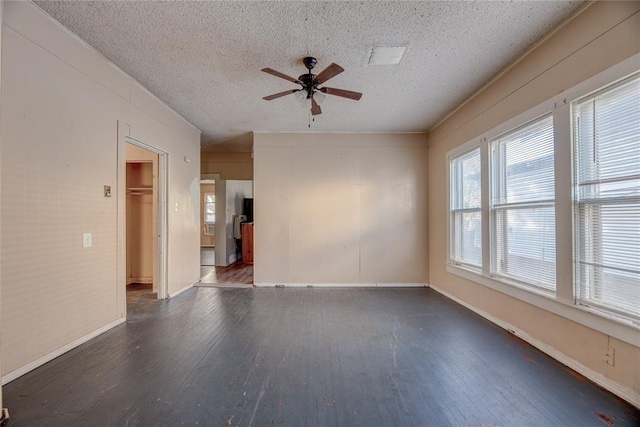 empty room with ceiling fan, dark wood-type flooring, and a textured ceiling