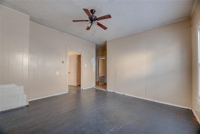 empty room with dark hardwood / wood-style floors, ceiling fan, and a textured ceiling