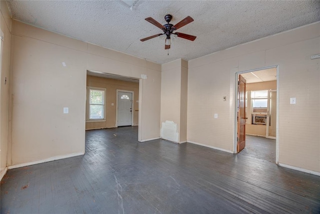 empty room with a textured ceiling, ceiling fan, and dark wood-type flooring