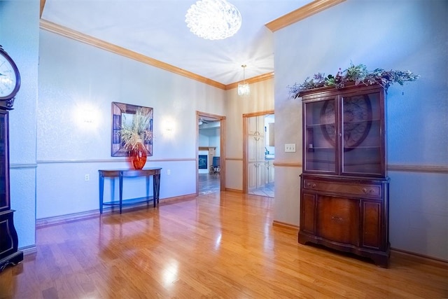 interior space featuring hardwood / wood-style flooring, ornamental molding, and an inviting chandelier