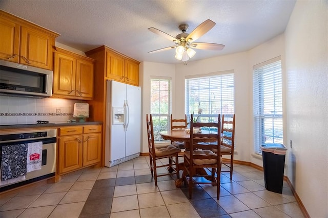 kitchen featuring appliances with stainless steel finishes, tasteful backsplash, light tile patterned floors, and a healthy amount of sunlight