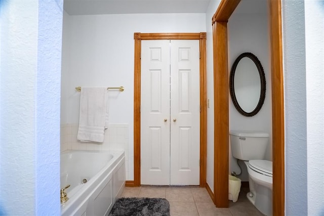 bathroom with tile patterned flooring, toilet, and a tub