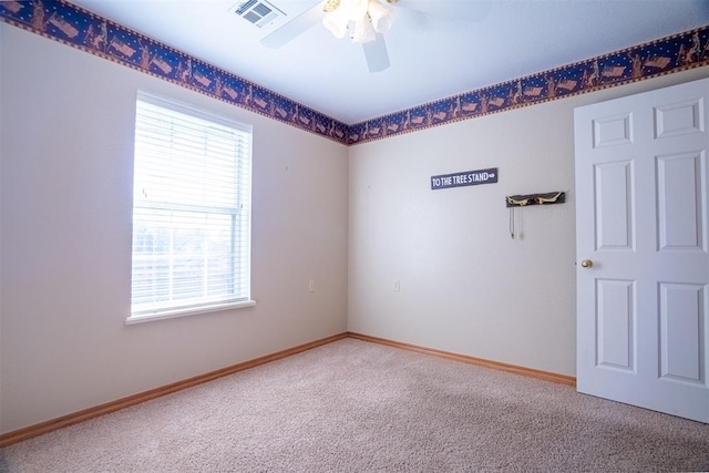 spare room with carpet flooring, a wealth of natural light, and ceiling fan