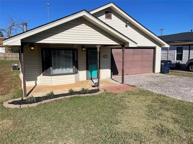 view of front of house featuring a porch, a garage, a front yard, and central AC