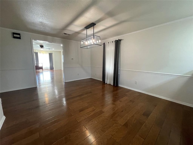 unfurnished dining area featuring dark hardwood / wood-style flooring, a textured ceiling, and ornamental molding