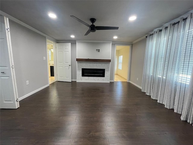 unfurnished living room with ceiling fan, ornamental molding, and dark wood-type flooring